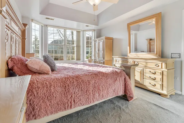 a large bed sitting in a bedroom next to a window