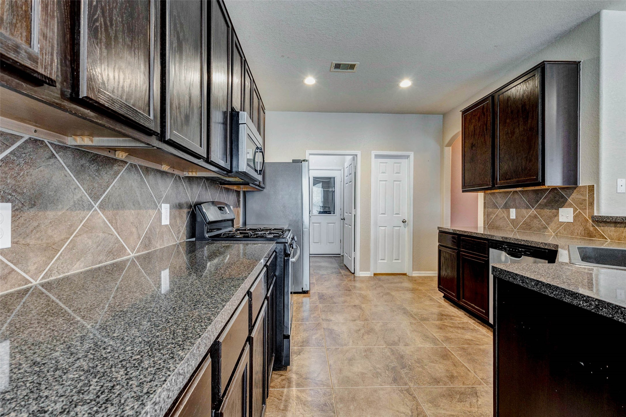 7638 Alum Lane Baytown, TX 77521 - Photo 13 of 44 a kitchen with stainless steel appliances granite countertop a sink a stove and a refrigerator