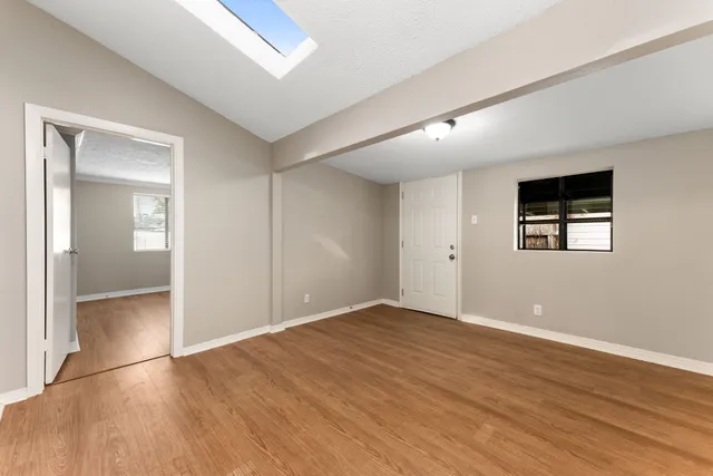 a view of an empty room with wooden floor