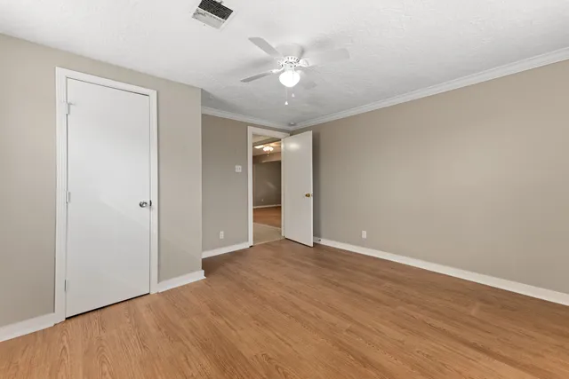a view of an empty room with wooden floor