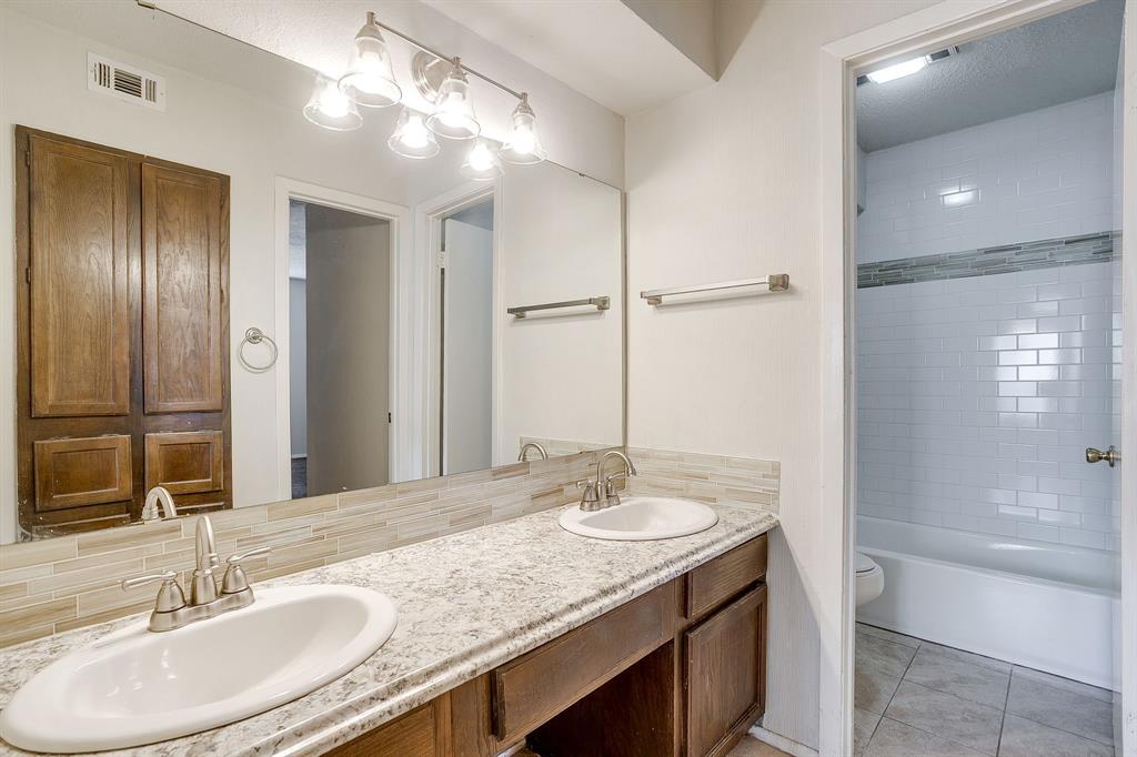 3400 Sanguinet Street, Unit RIGHT Fort Worth, TX 76107 - Photo 15 of 22 a bathroom with a granite countertop sink a toilet a mirror and shower