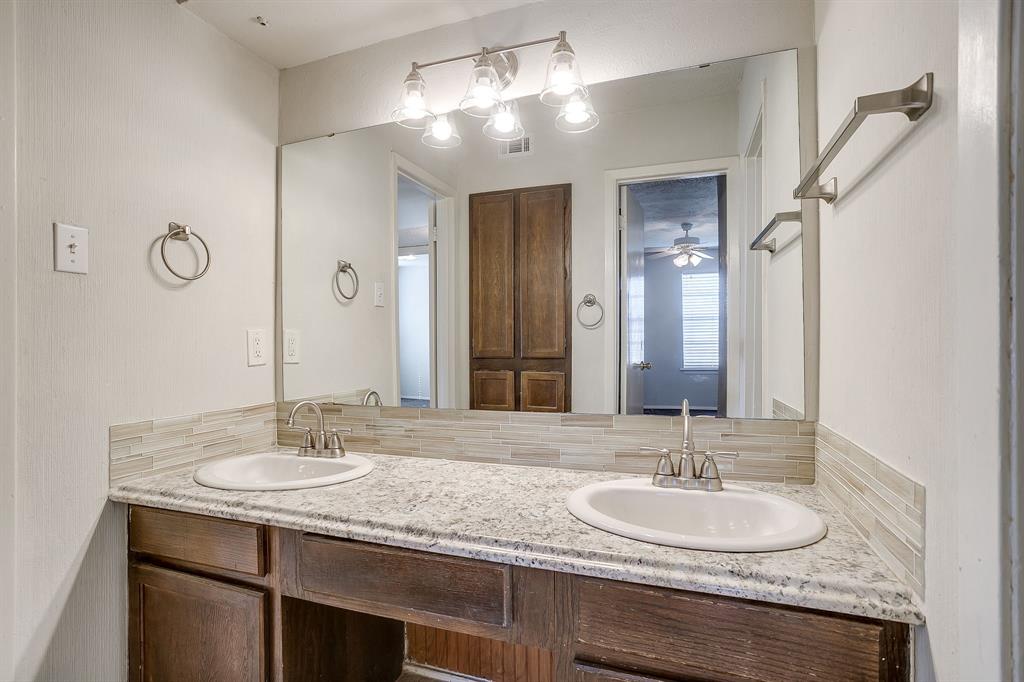 3400 Sanguinet Street, Unit RIGHT Fort Worth, TX 76107 - Photo 16 of 22 a bathroom with a granite countertop sink a light fixture and a mirror