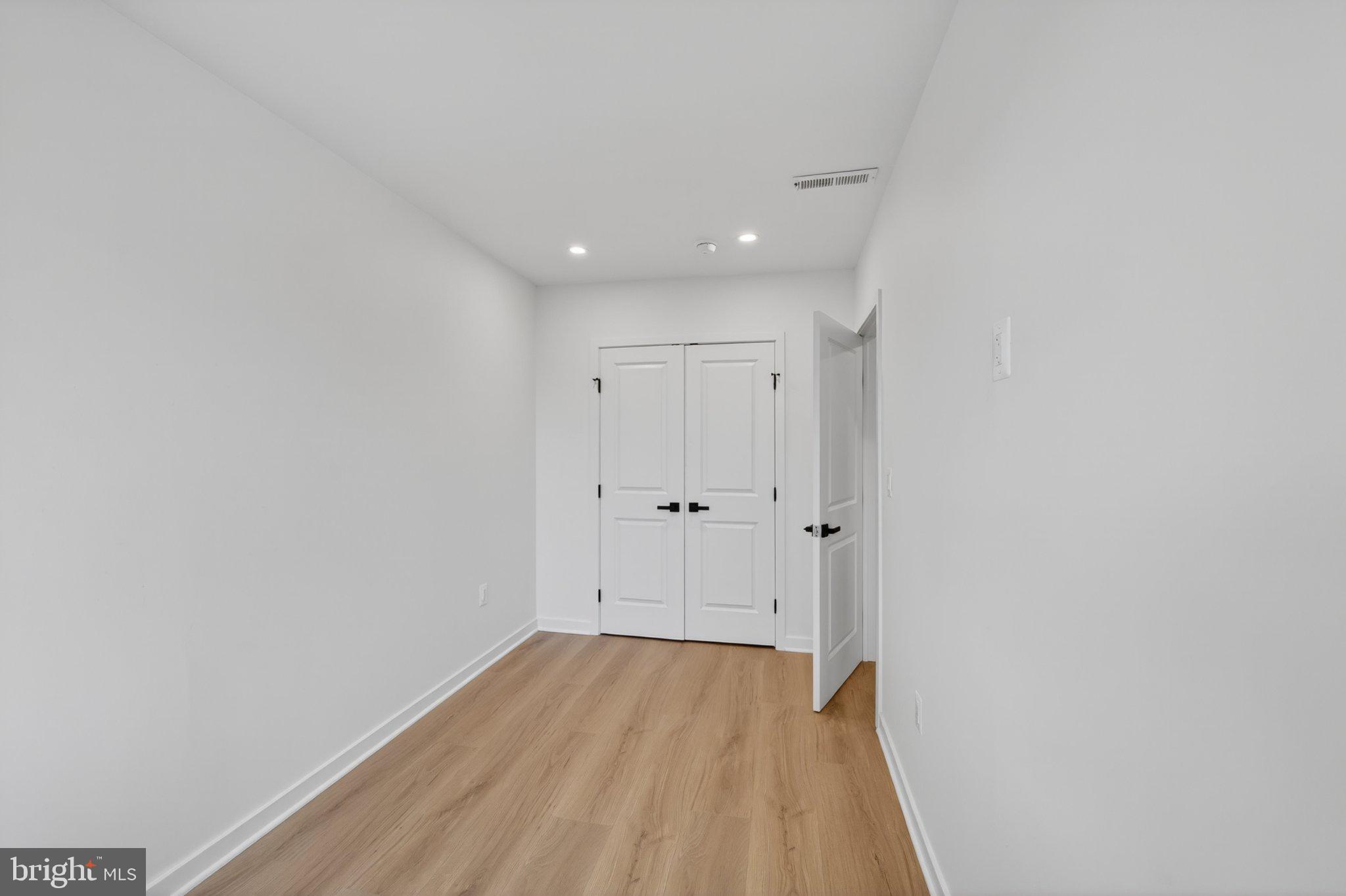 412 Newcomb Street Southeast Washington, DC 20032 - Photo 20 of 34 a view of a room with wooden floor and white doors