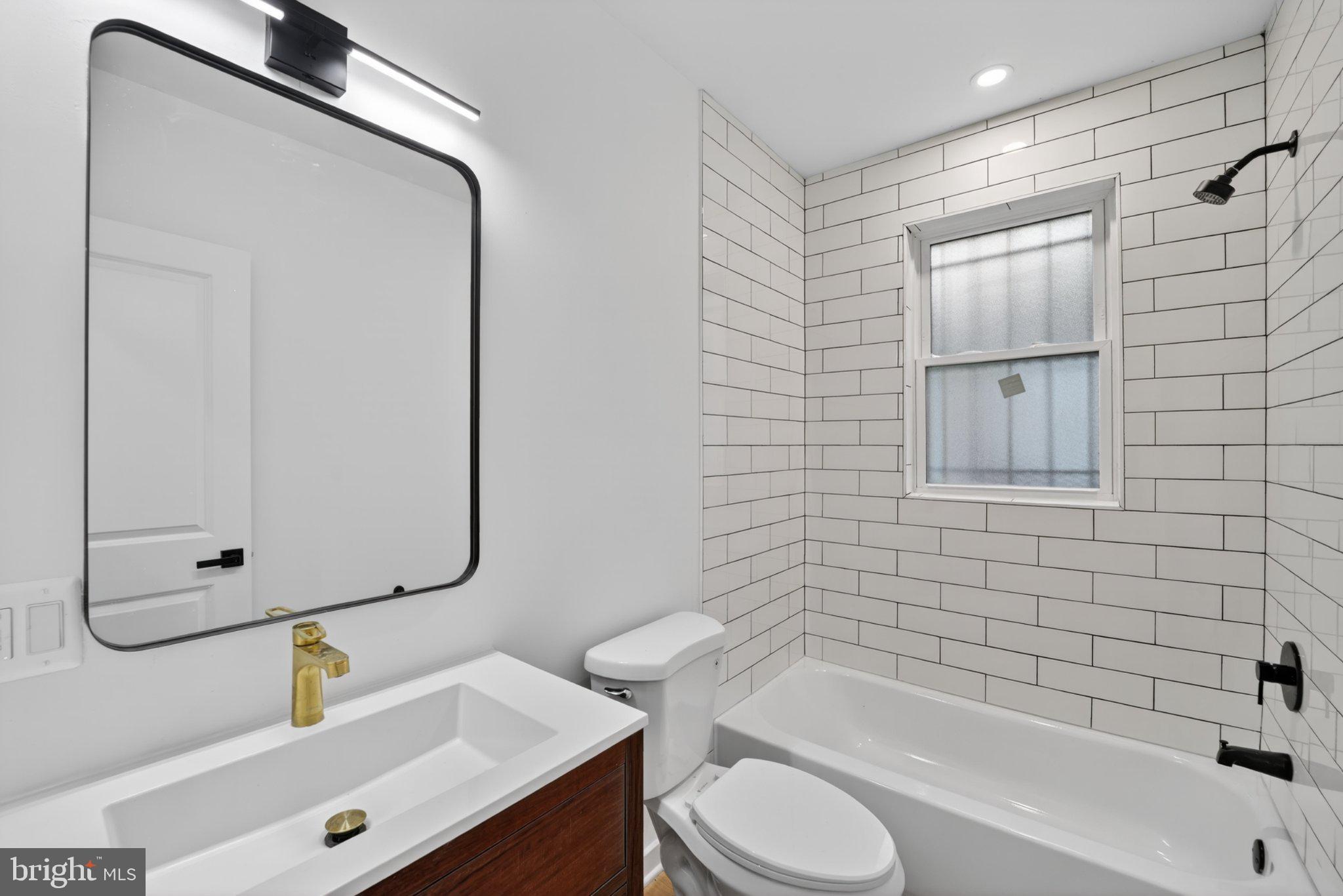 412 Newcomb Street Southeast Washington, DC 20032 - Photo 10 of 34 a bathroom with a bathtub shower sink vanity and toilet