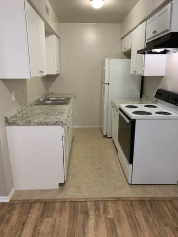 a kitchen with a stove and a white refrigerator