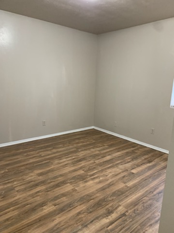 2701 Poplar Circle, Unit H Bryan, TX 77801 - Photo 4 of 8 a view of an empty room with wooden floor