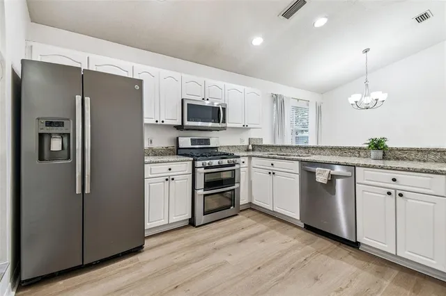 a kitchen with stainless steel appliances granite countertop a stove and a sink