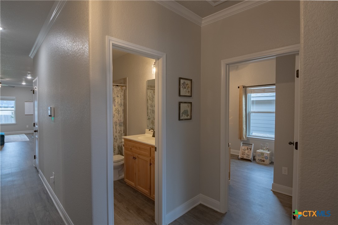 7909 McCulloch Road Temple, TX 76502 - Photo 8 of 46 a view of a hallway with bathroom and wooden floor
