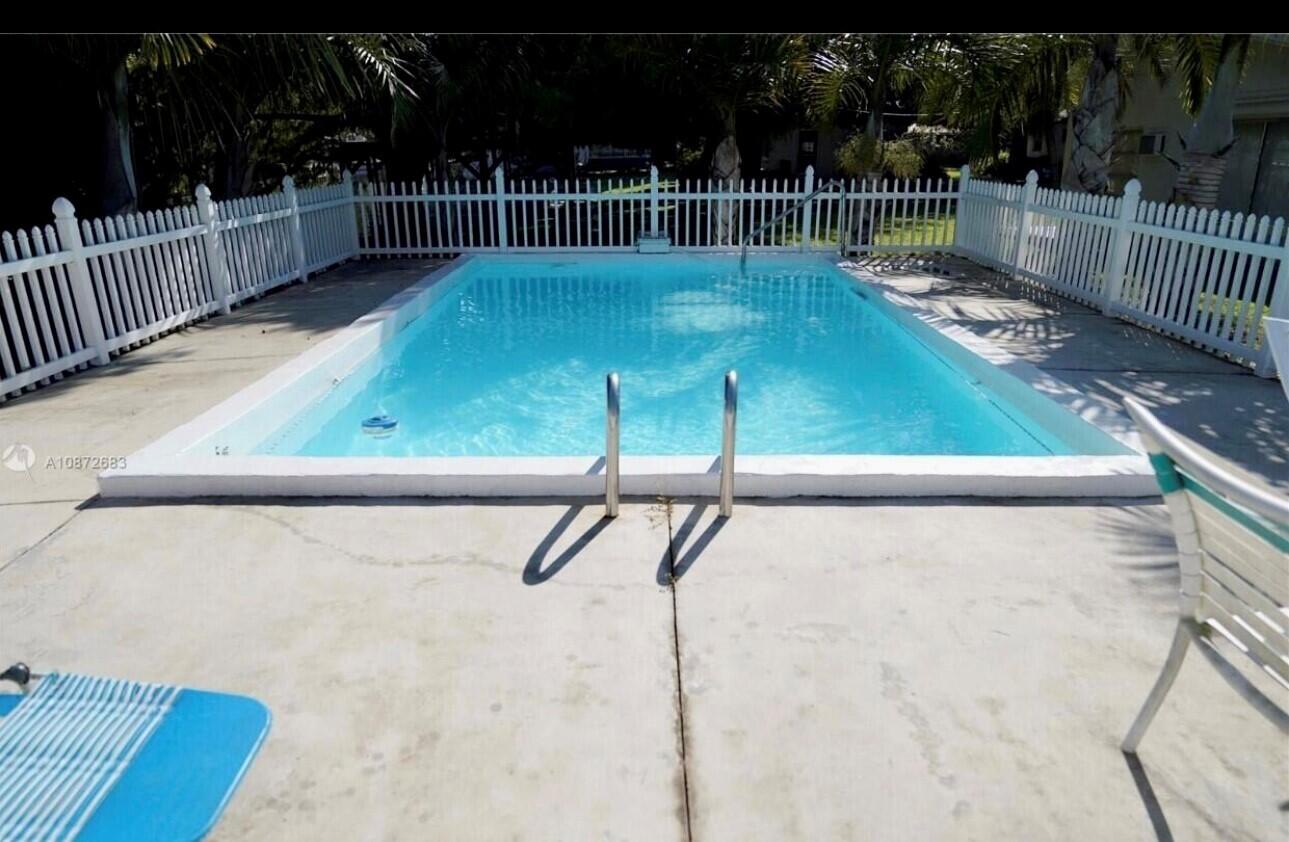 3203 Southeast 29th Lane, Unit 4 Okeechobee, FL 34974 - Photo 12 of 14 a view of a tennis court with wooden fence