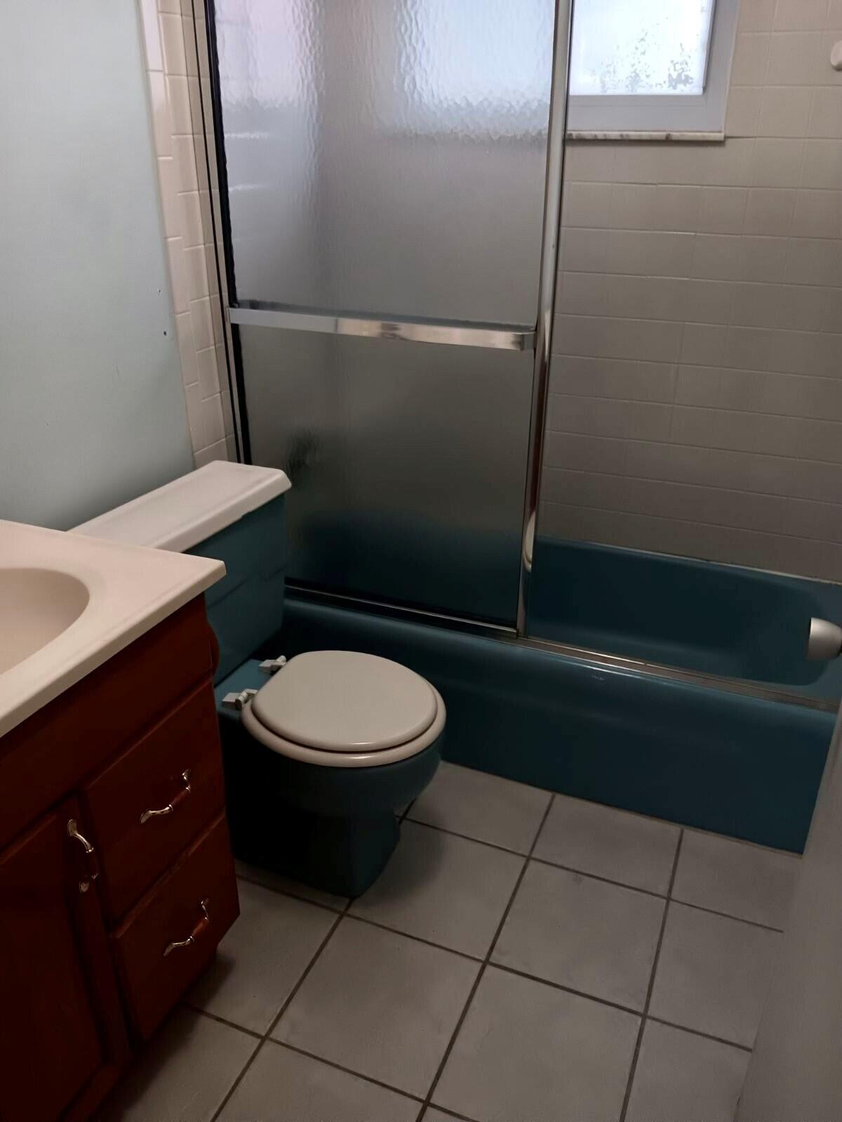 3203 Southeast 29th Lane, Unit 4 Okeechobee, FL 34974 - Photo 9 of 14 a bathroom with a granite countertop toilet and a sink