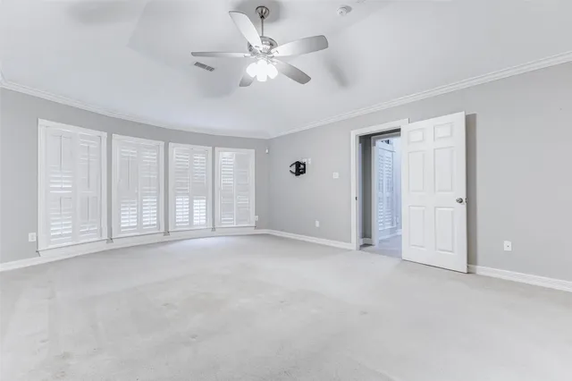 an empty room with a ceiling fan and a window
