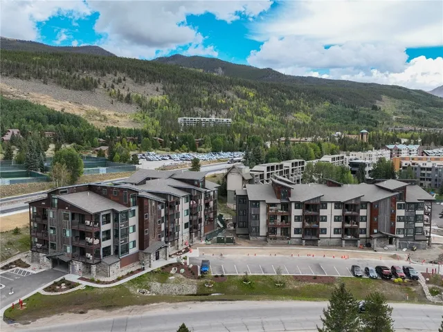 an aerial view of residential houses with outdoor space and lake view