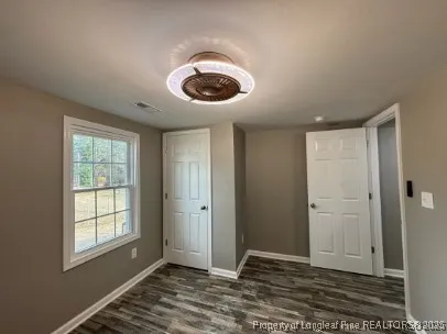 a view of an empty room with window and cabinet area