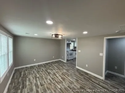 a view of empty room with wooden floor