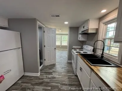 a kitchen with granite countertop a refrigerator stove and sink