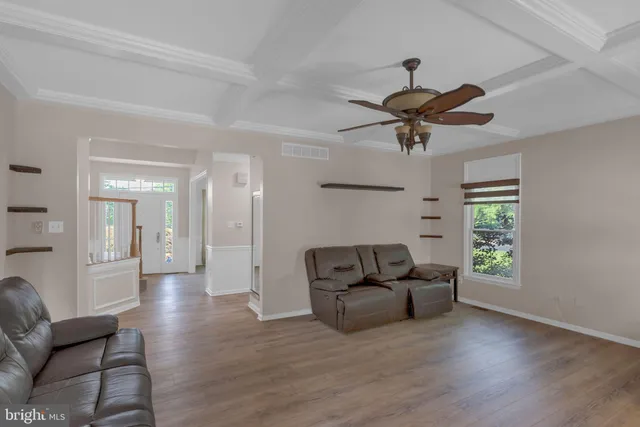 a view of a room with wooden floor staircase and a chandelier