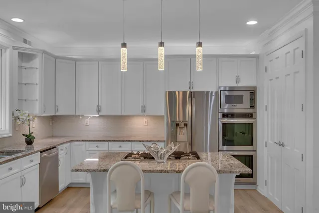 a kitchen with stainless steel appliances granite countertop a sink a stove and a granite counter tops with a window