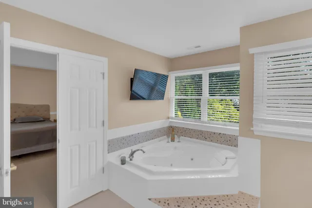 a view of a hallway with wooden floor and a living room