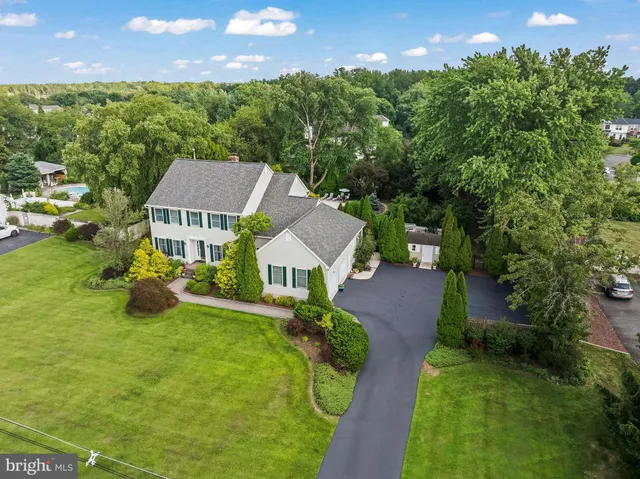 an aerial view of residential houses with outdoor space and trees