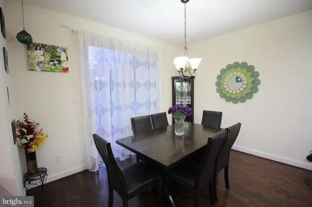 a dining room with furniture potted plants and wooden floor