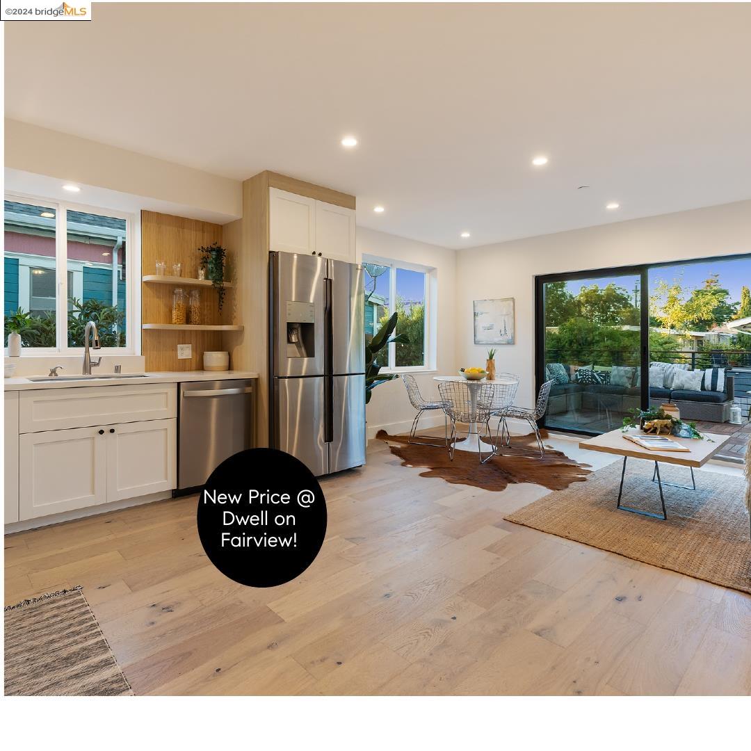 a living room with stainless steel appliances furniture a rug and a view of kitchen