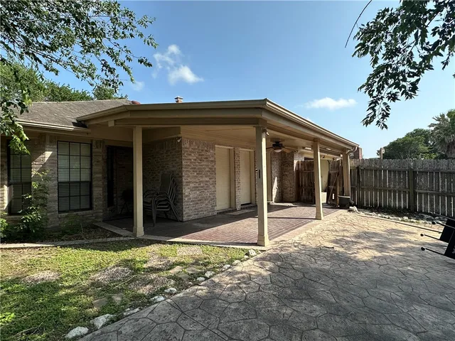 a view of house with small yard and large tree
