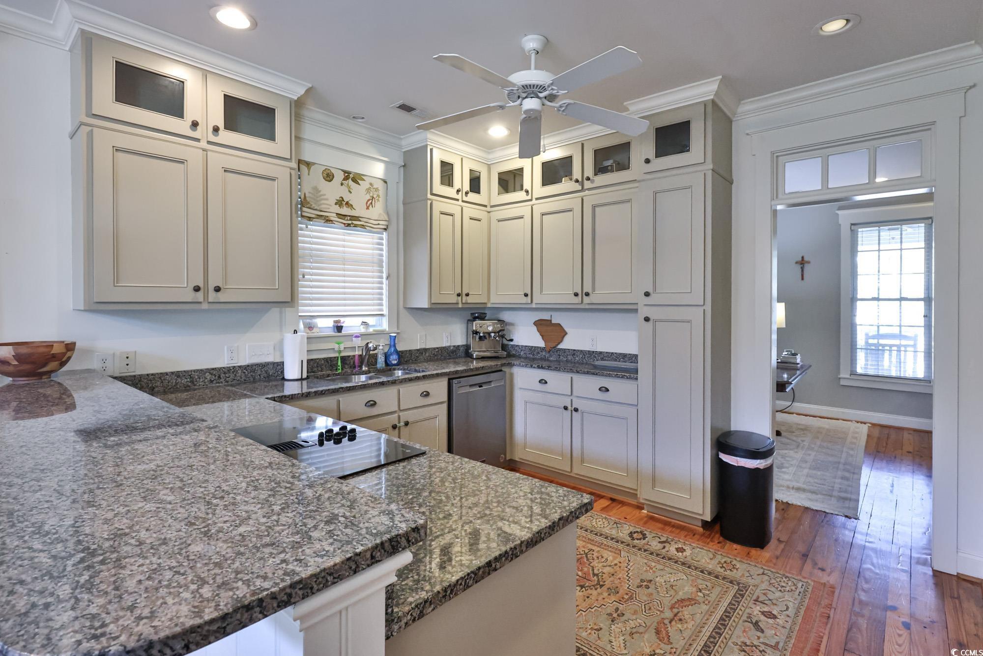 998 Shipmaster Avenue Myrtle Beach, SC 29579 - Photo 15 of 40 Kitchen with ornamental molding, light wood finished floors, dark stone counters, dishwasher, and glass insert cabinets