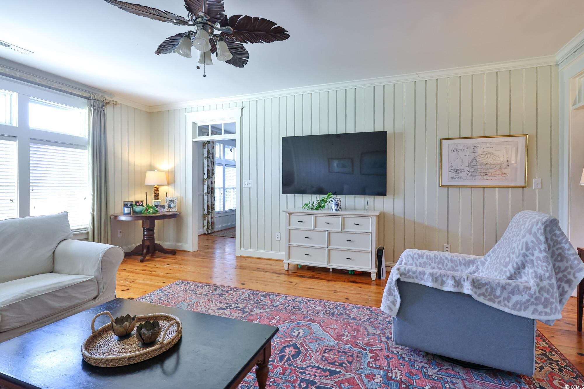 998 Shipmaster Avenue Myrtle Beach, SC 29579 - Photo 18 of 40 Living room with ornamental molding, wood walls, hardwood / wood-style flooring, and ceiling fan