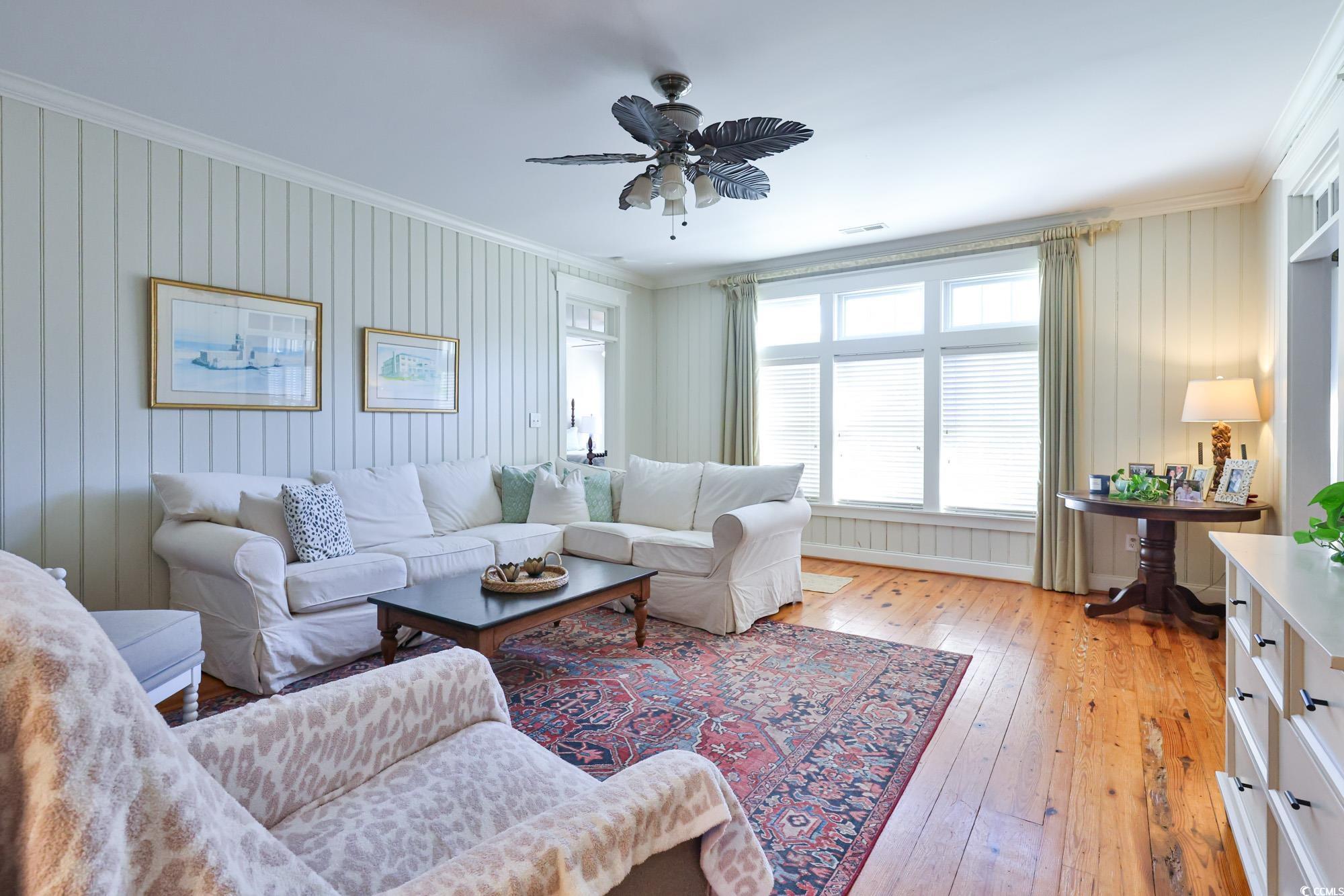 998 Shipmaster Avenue Myrtle Beach, SC 29579 - Photo 19 of 40 Living room with crown molding, light wood-type flooring, ceiling fan, and wooden walls
