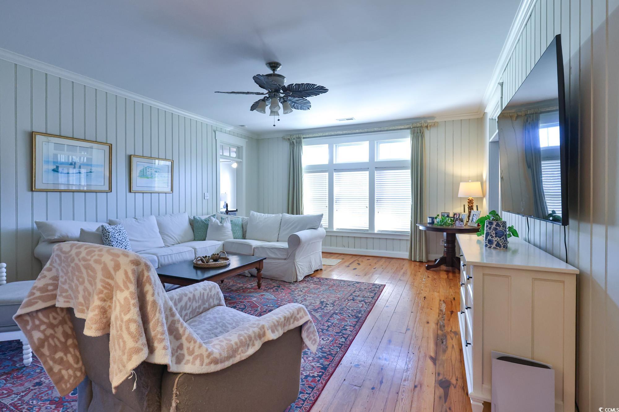 998 Shipmaster Avenue Myrtle Beach, SC 29579 - Photo 20 of 40 Living room featuring crown molding, light wood-type flooring, healthy amount of natural light, ceiling fan, and wooden walls