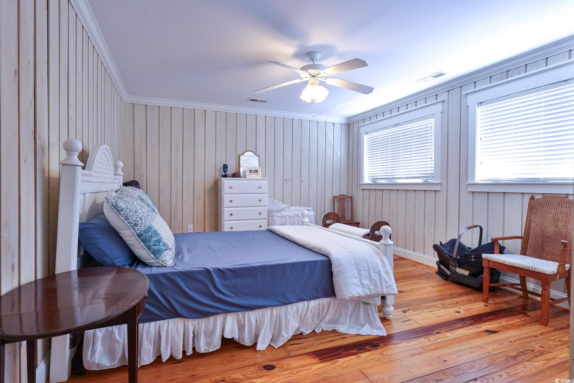 998 Shipmaster Avenue Myrtle Beach, SC 29579 - Photo 23 of 40 Bedroom featuring ornamental molding, wood-type flooring, wooden walls, and ceiling fan