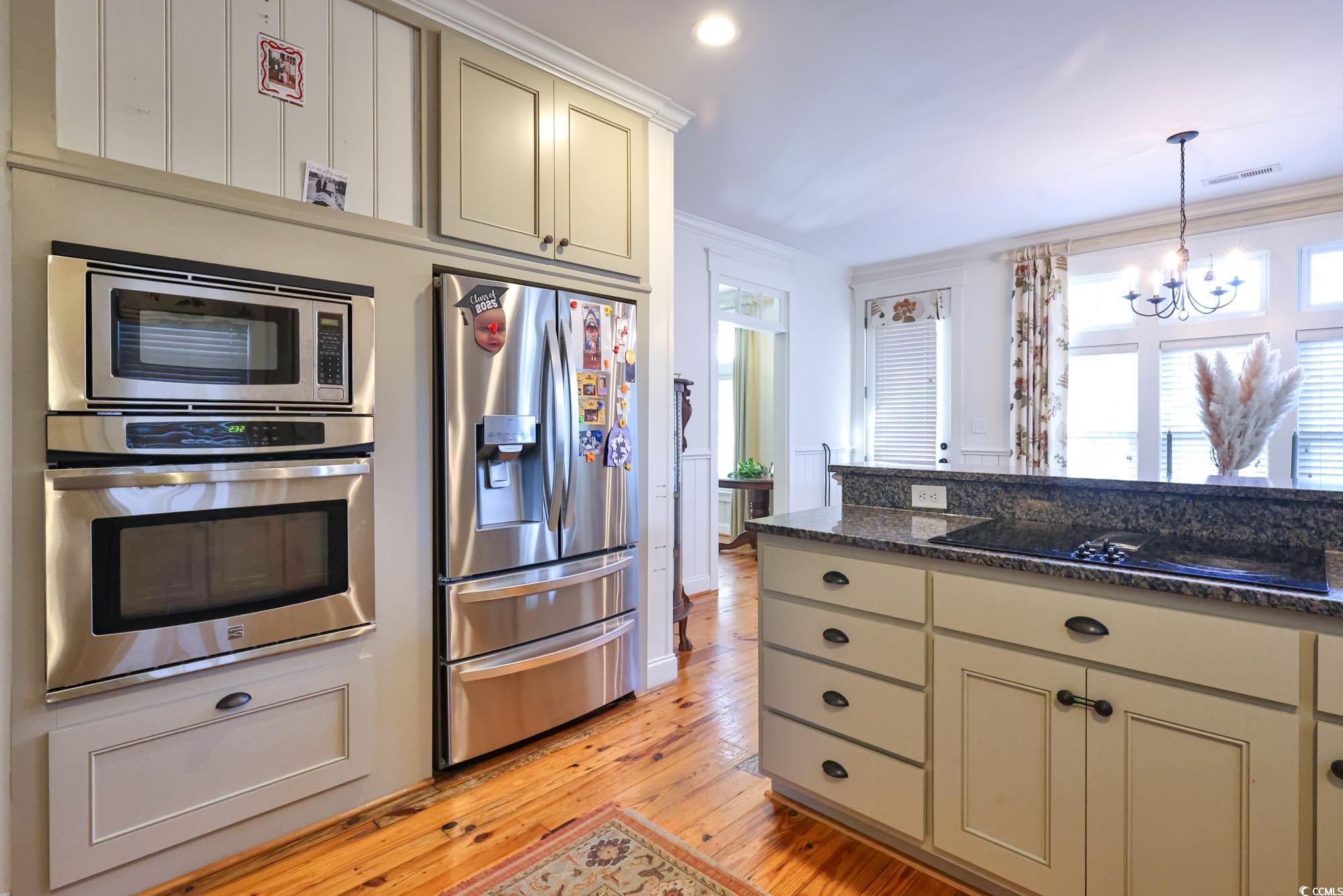 998 Shipmaster Avenue Myrtle Beach, SC 29579 - Photo 37 of 40 Kitchen with cream cabinets, appliances with stainless steel finishes, dark stone countertops, light wood-type flooring, and ornamental molding