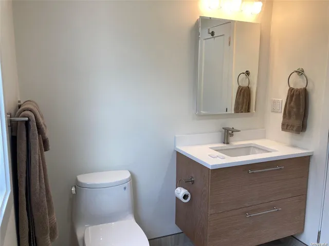 a bathroom with a toilet sink and mirror