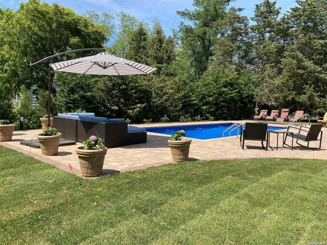 a view of a backyard with swimming pool and furniture
