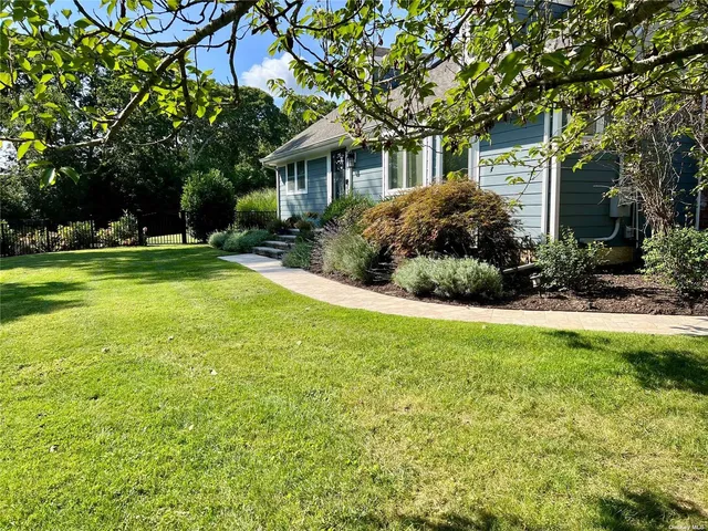 a view of a house with a yard and sitting area