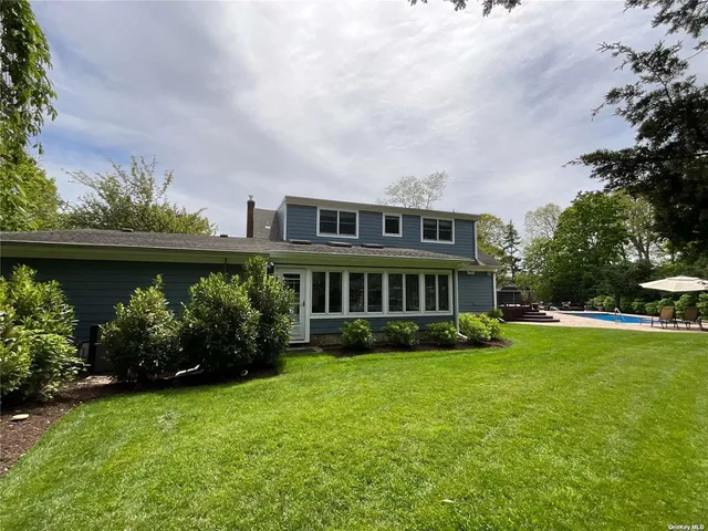 a view of a house with a yard and potted plants