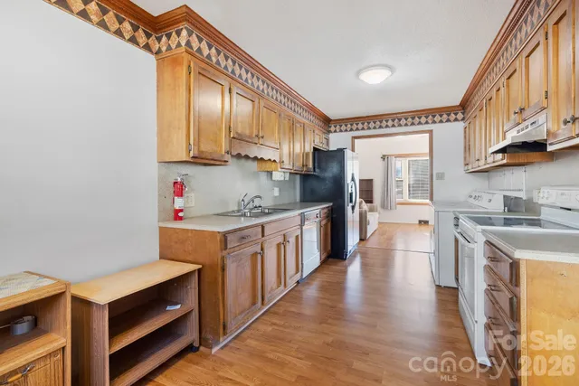 a kitchen with stainless steel appliances granite countertop a sink a stove and a refrigerator