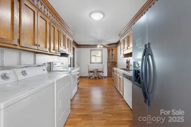 a large kitchen with stainless steel appliances lots of counter space and wooden floor