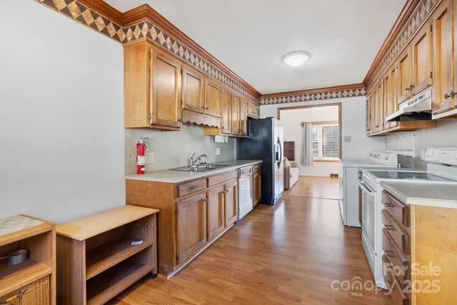 a kitchen with stainless steel appliances granite countertop a sink a stove and a refrigerator