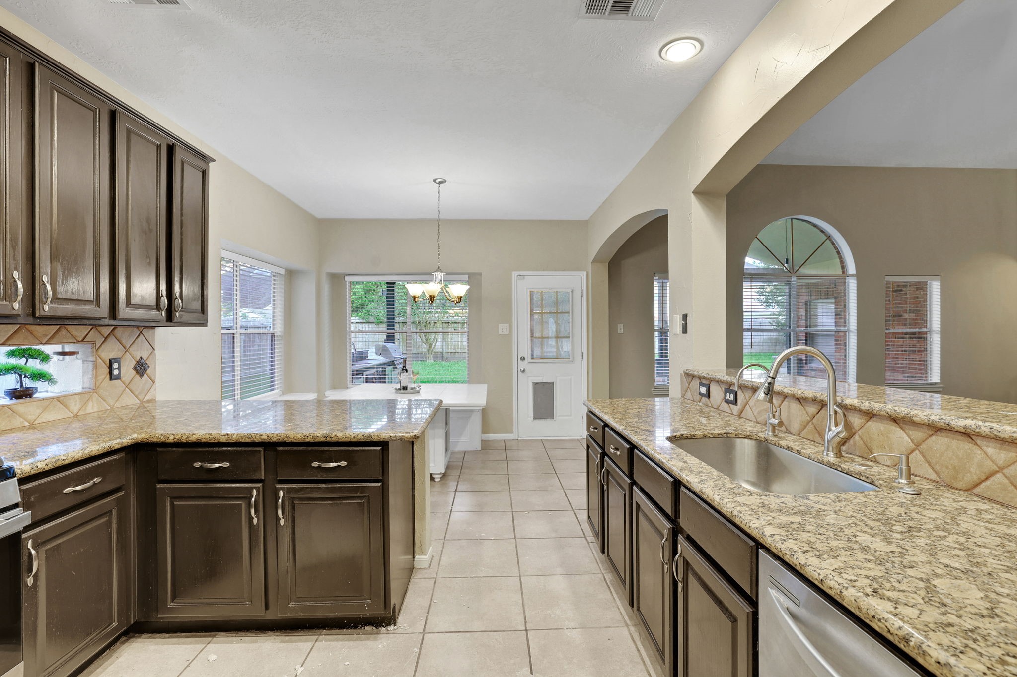 23207 Olive Ridge Court Katy, TX 77494 - Photo 11 of 46 a large kitchen with granite countertop a sink and dishwasher with a large kitchen island