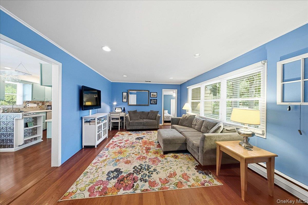 10 Graham Road Hampton Bays, NY 11946 - Photo 9 of 26 a living room with furniture flat screen tv and a fireplace