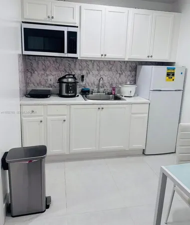 a kitchen with stainless steel appliances white cabinets and a refrigerator