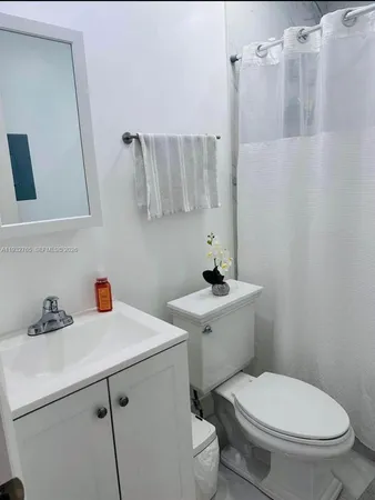 a bathroom with a sink a toilet and shower curtain