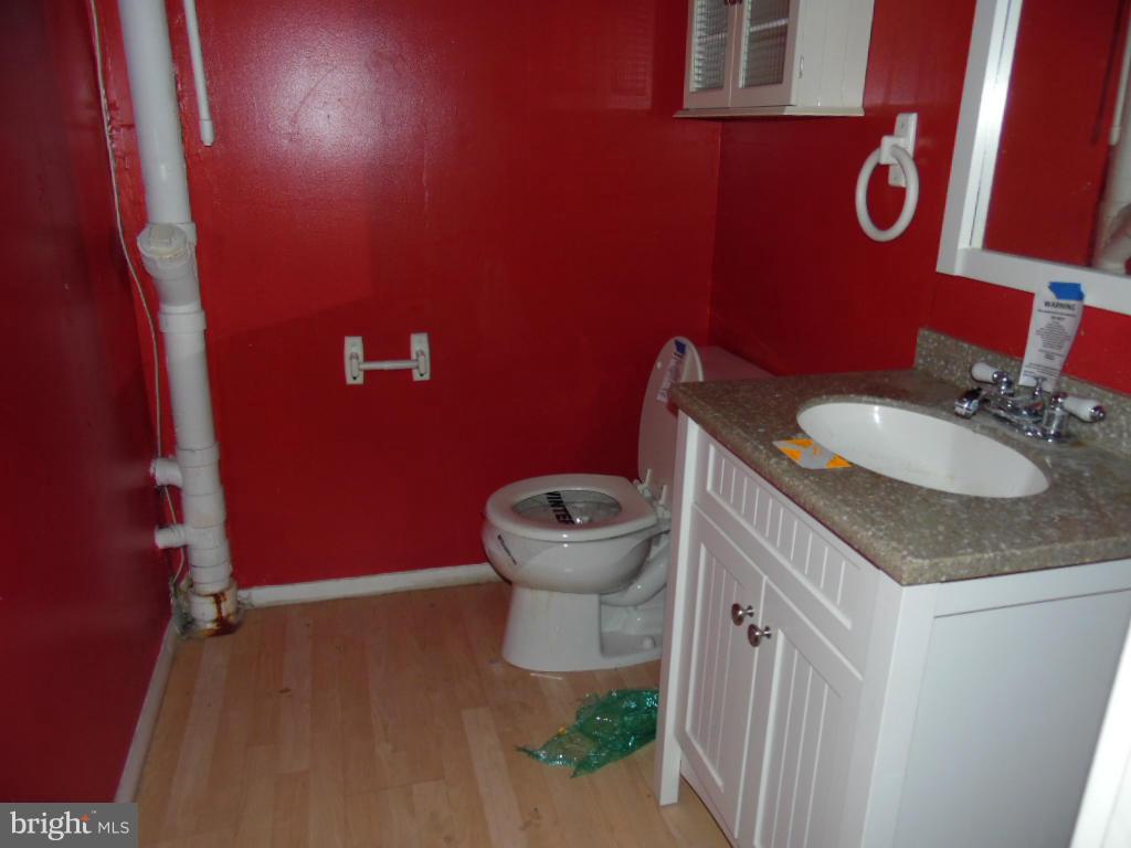 7921 Lynch Road Baltimore, MD 21222 - Photo 19 of 21 a bathroom with a granite countertop toilet and a sink