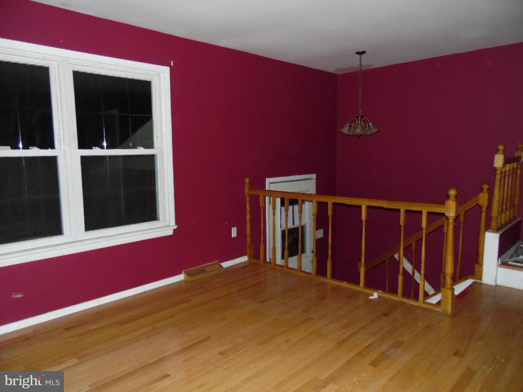 7921 Lynch Road Baltimore, MD 21222 - Photo 3 of 21 a view of an empty room with wooden floor and a window