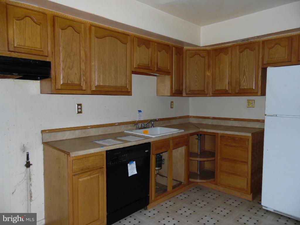 7921 Lynch Road Baltimore, MD 21222 - Photo 5 of 21 a utility room with stainless steel appliances wooden cabinets and a sink