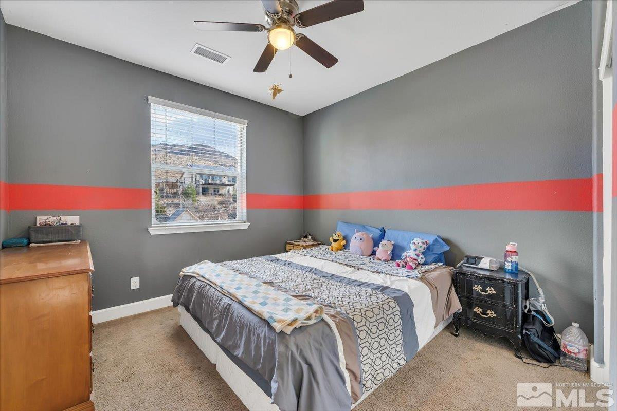 10050 Barrel Racer Drive Reno, NV 89521 - Photo 24 of 30 a bedroom with a bed and a chandelier