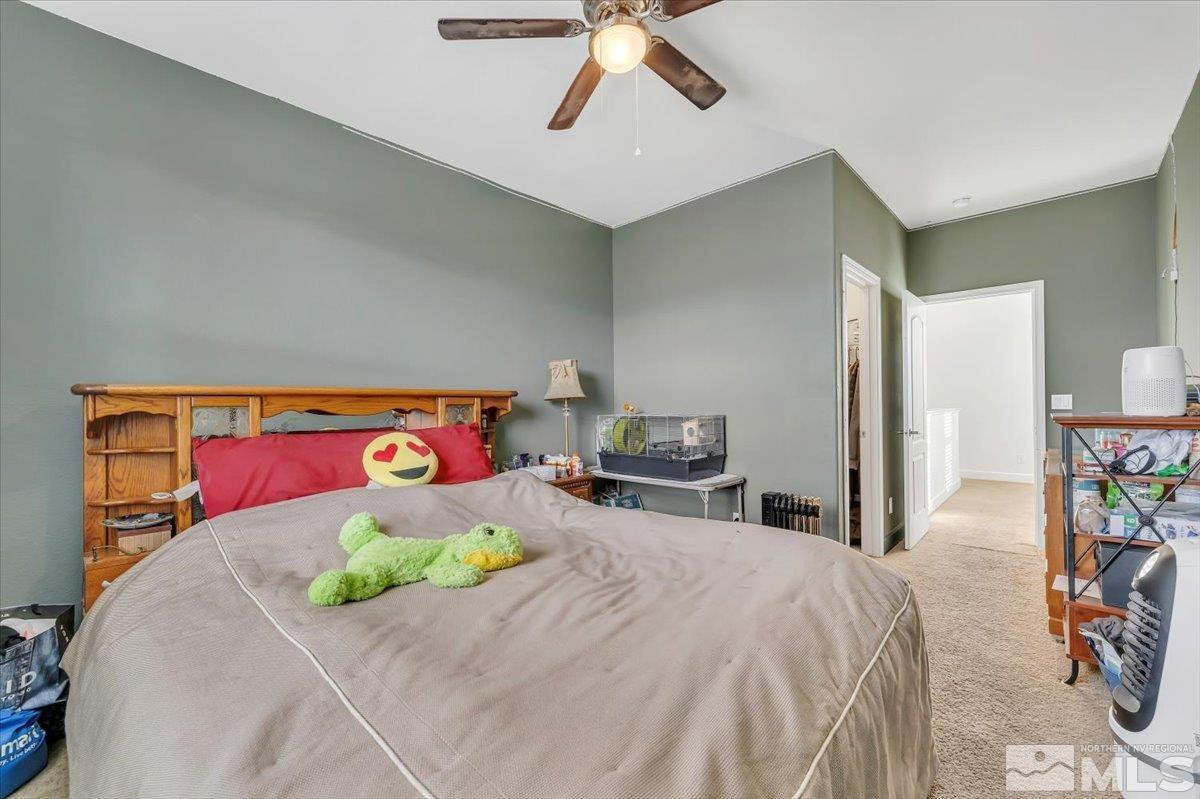 10050 Barrel Racer Drive Reno, NV 89521 - Photo 26 of 30 a bedroom with a bed and a chandelier