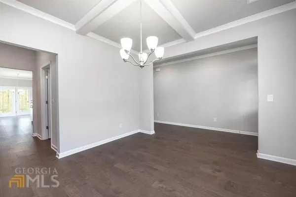 an empty room with fan and wooden floor