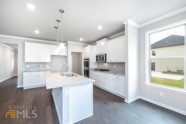 1916 Endress Circle Hampton, GA 30228 - Photo 9 of 17 a large kitchen with kitchen island a sink a stove a center island and wooden floor